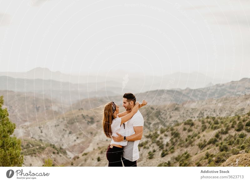 Young couple in love enjoying in mountains happy romantic nature young journey together having fun excited hill relationship travel vacation cheerful trip