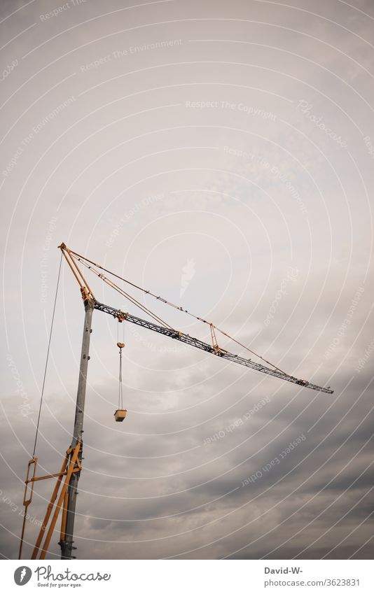 a crane on a building site Crane Sky Clouds great huge Tall Construction site somber Thunder and lightning Storm Gray construction stop Build standstill Above
