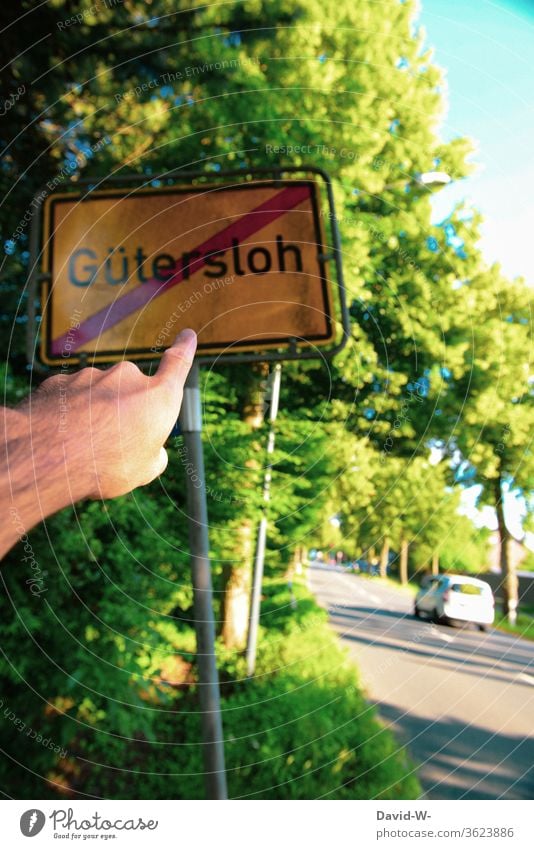 Man points to the Gütersloh place-name sign crossed out Rheda-Wiedenbrück Oelde cordon keep sb./sth. apart gap Safety covid-19 Tönnies Hotspots Corona hotspots