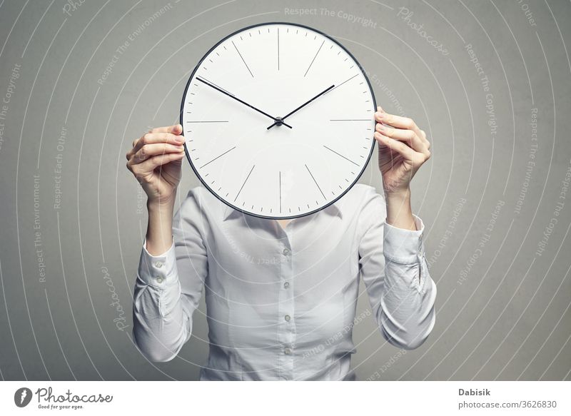 business woman covering her face with clock anonymous unknown head portrait secretary female adult people corporate caucasian white confident closeup blouse