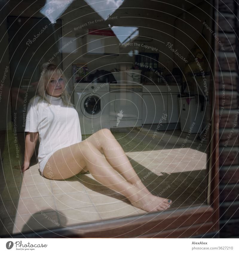 Analogue portrait of a young woman behind a window in a washroom girl Young woman already Blonde long hairs youthful 19 18-20 years 15-20 years old fit Esthetic