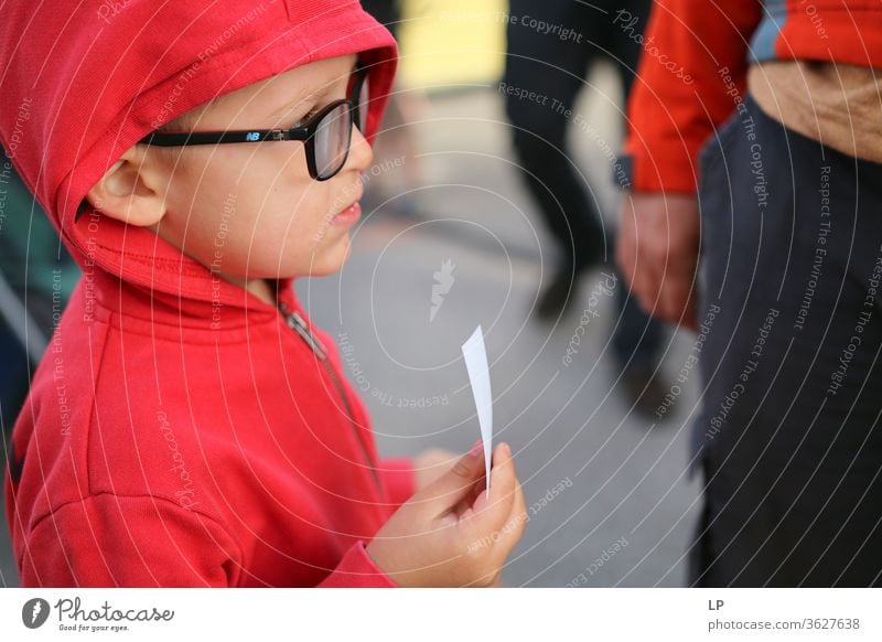 child with a ticket waiting in line Child Ticket Wait Loneliness Think Sadness lonely Exterior shot Transport Exchange of information Information Communicate