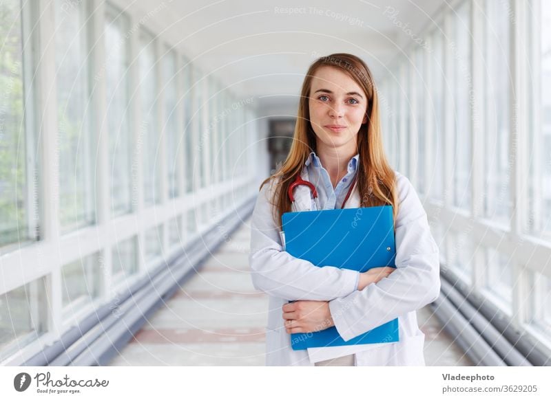 Medical doctor woman over clinic interiers background. young female portrait white smile health hospital intern specialist medical stethoscope girl job care