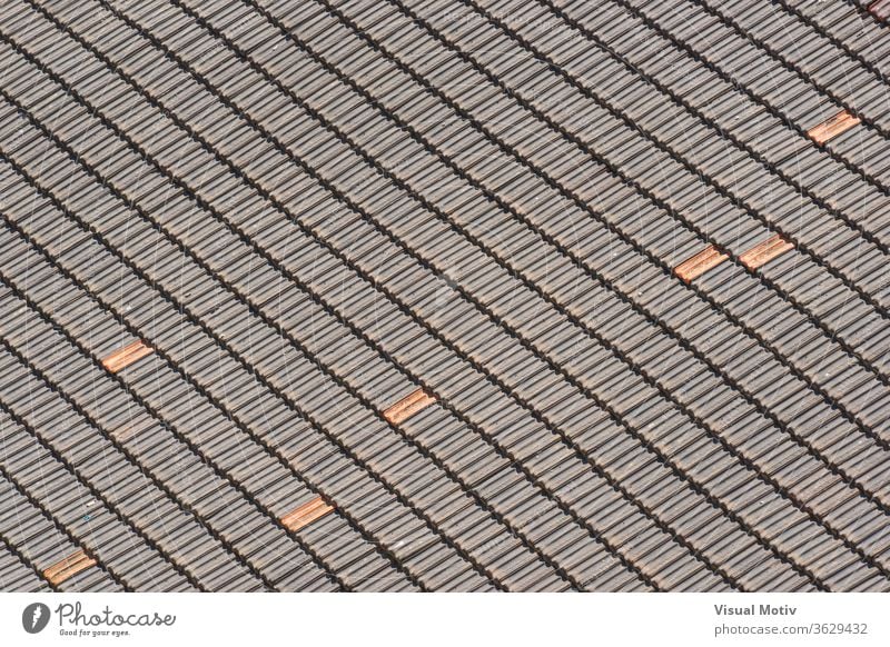 Background of traditional terracotta tiles of an old roof forming a diagonal pattern roof-tile texture building ceramic abstract sunny background architecture