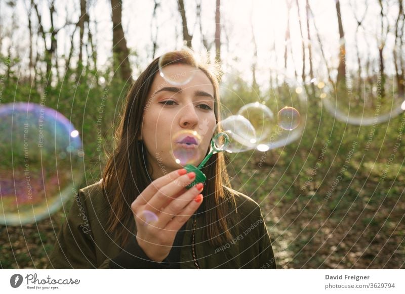 Young woman blowing soap bubbles in the woods. freedom networking women people happy careless fun leisure forest connect vintage enjoyment share outdoor cute