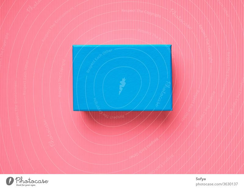 Blue gift box on pink coral background surprise blue minimal present give birthday vibrant color block secret closed holiday concept top view flat lay