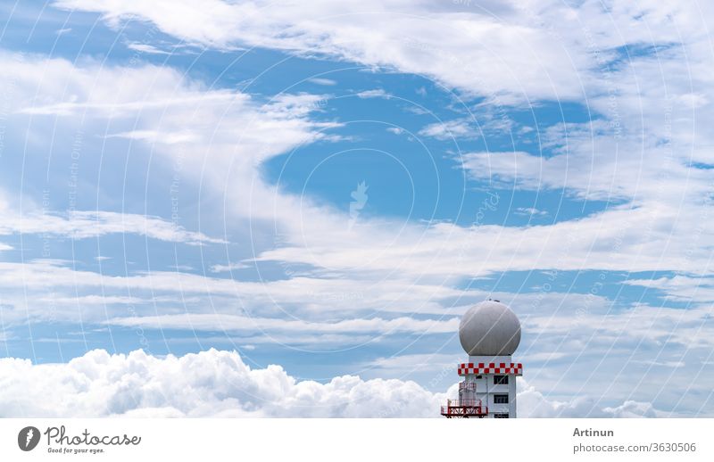 Weather observations radar dome station against blue sky and white fluffy clouds. Aeronautical meteorological observations station tower use for safety aircraft in aviation business. Spherical tower.