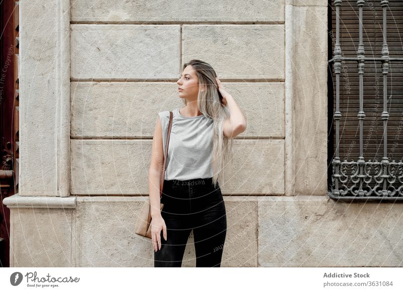 Woman standing on street on concrete wall woman city using young style browsing female lifestyle urban trendy lady millennial pedestrian building content