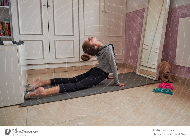 Teen girl stretching on mat in own room gymnastic home child flexible art exercise training skinny posture practice pose balance spine bend focus determine