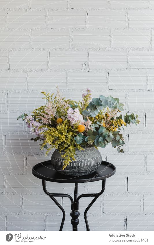 Ceramic vase with colorful flowers on table bouquet floristry fresh natural various pot creative beautiful eucalyptus goldenrod craspedia plant decor design