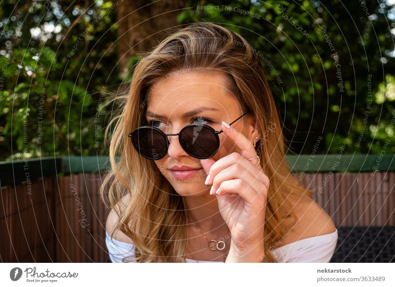 Pretty Blond Woman with Sunglasses Looking Away lifestyle blond young woman looking away vanity close up terrace summer one woman only caucasian ethnicity