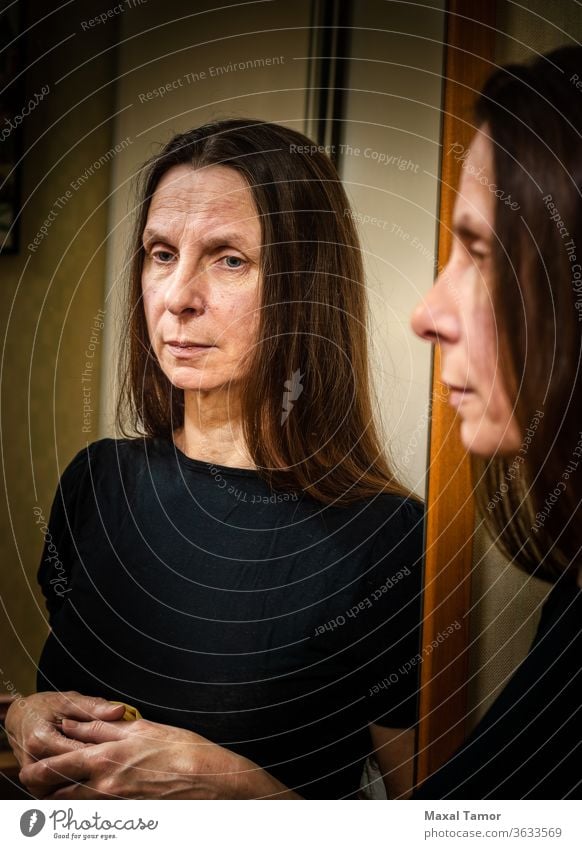 Portrait of an adult woman  reflecting in a mirror 60s Domestic Life aged attractive beautiful beauty brunette casual caucasian elderly expression face female