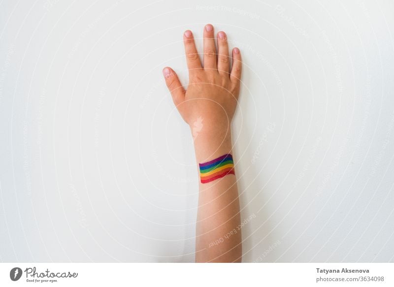 Rised child hand with rainbow LGBTQ pride flag tattoo lgbtq freedom gay lesbian homosexual symbol raised rights colorful bisexual love homosexuality concept