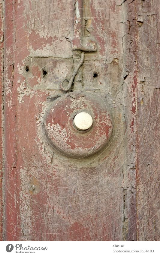 the bell button, which was painted wine-red and later grey a long time ago, peels off the colour as well as the wood on which it was fixed Bell dilapidated Gray