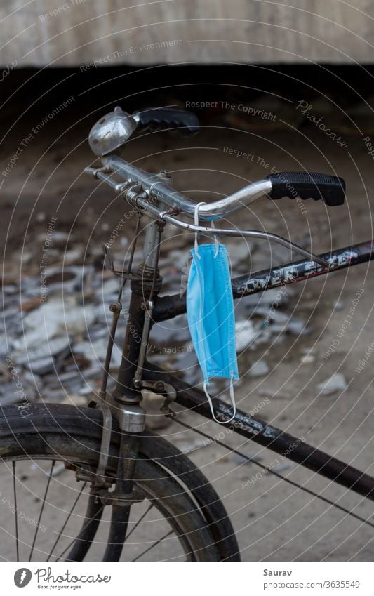 Disposable Medical Mask hanging on a Cycle handle. medical mask covid-19 lifestyle cycle disposable mask pandemic new normal recreation bicycle safety travel