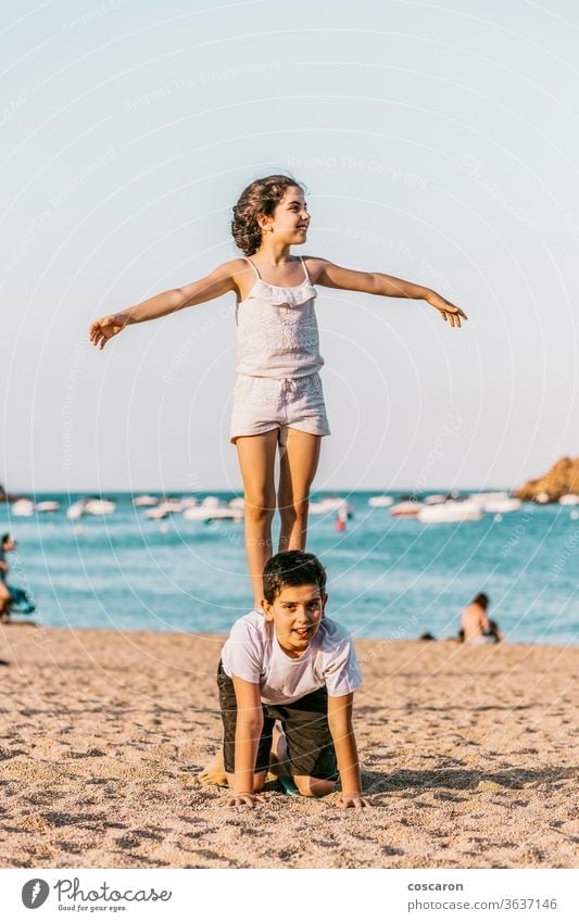 Two kids playing on the beach baby beautiful blue brother caucasian cheerful child childhood coast concepts cute daughter family fun girl happiness happy