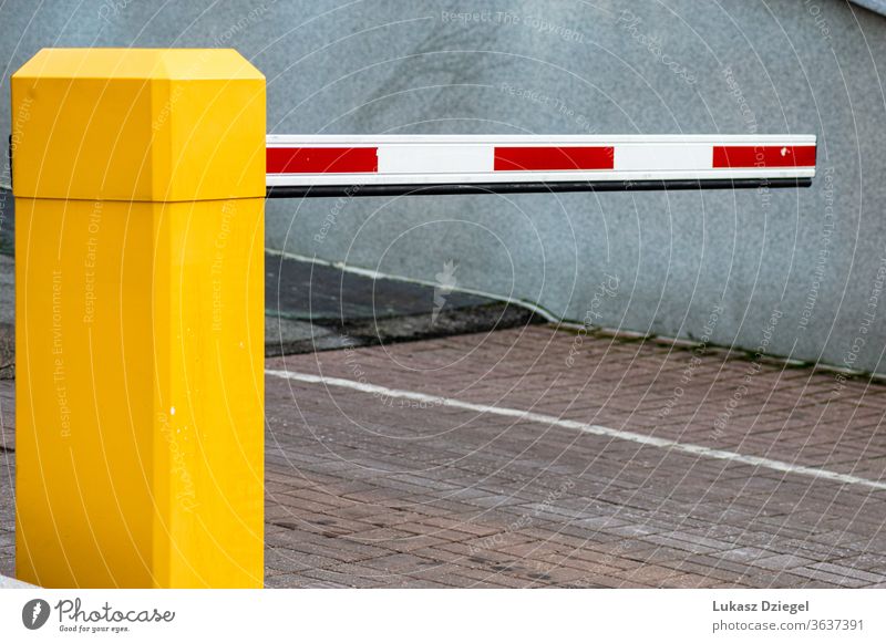 White and red entrance barrier on a yellow post Barrier Entrance Exterior shot Parking parking entrance Transport Parking garage red and white Gate parking gate