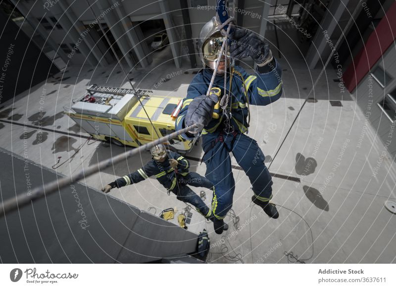 Firemen in uniform training with ropes firefighter climb firemen spacious equipment rescue complex practice healthy workout strong protect helmet hardhat