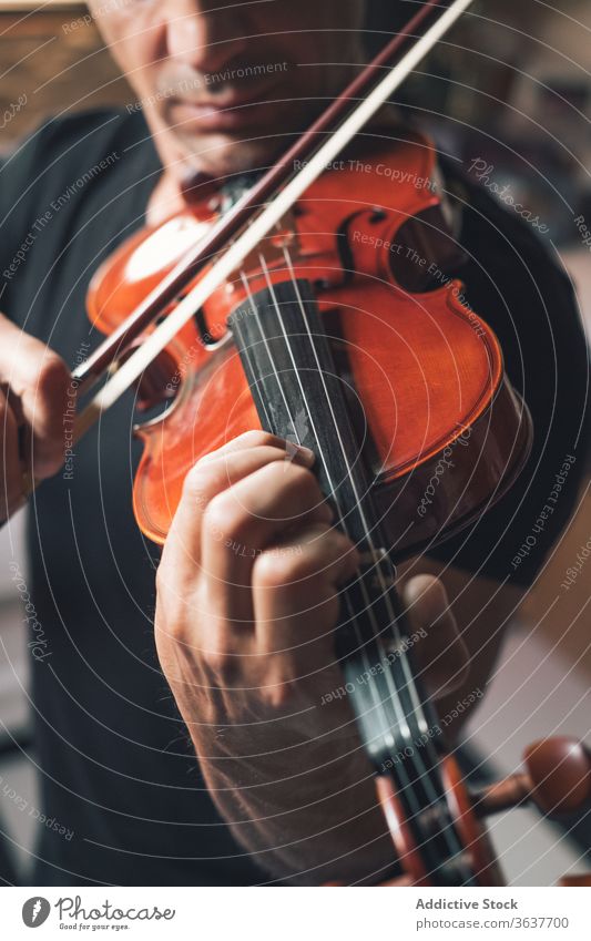 Anonymous male musician playing violin instrument man talent sheet violinist melody ethnic hispanic perform rehearsal sound entertain tune hobby rhythm player