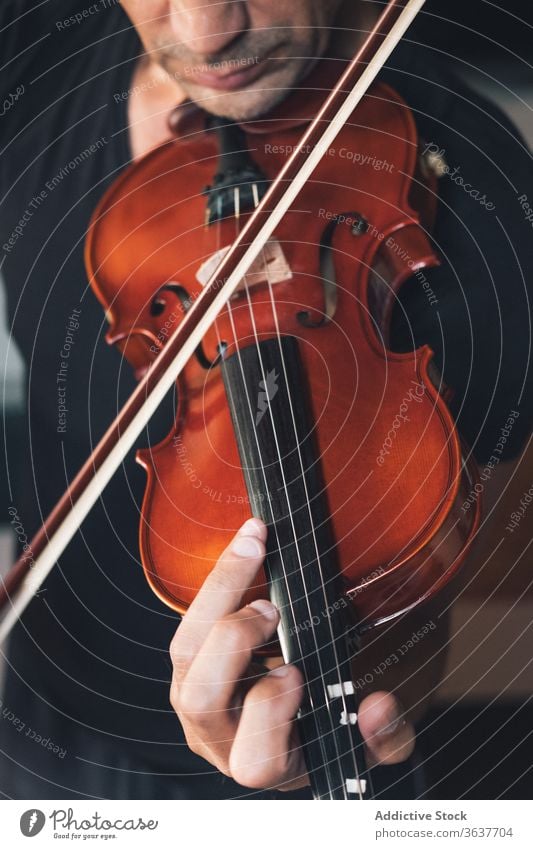Anonymous male musician playing violin instrument man talent sheet violinist melody ethnic hispanic perform rehearsal sound entertain tune hobby rhythm player