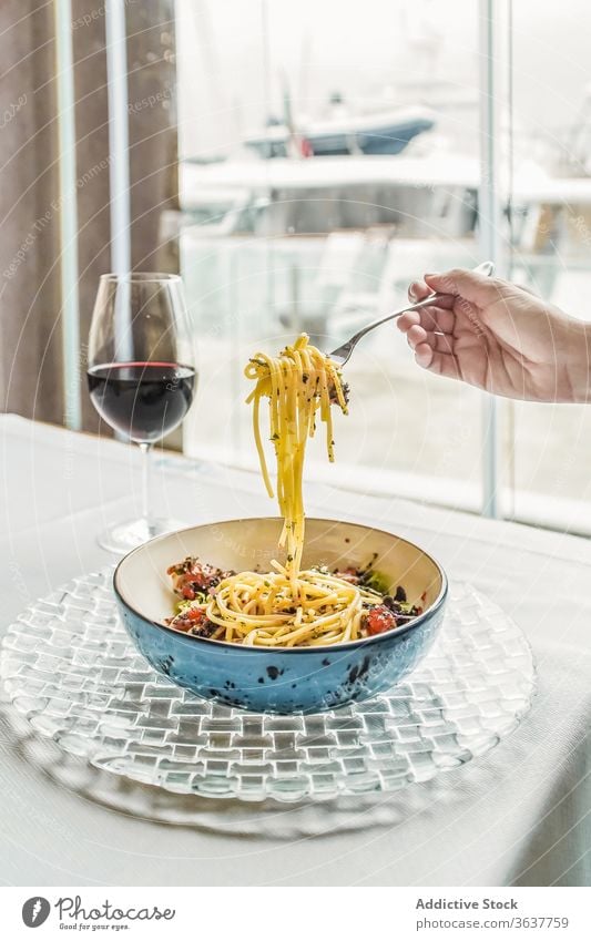 Crop person having pasta and glass of wine meal red wine home gourmet eat delicious dinner drink food beverage alcohol fork vegetable sauce simple italian