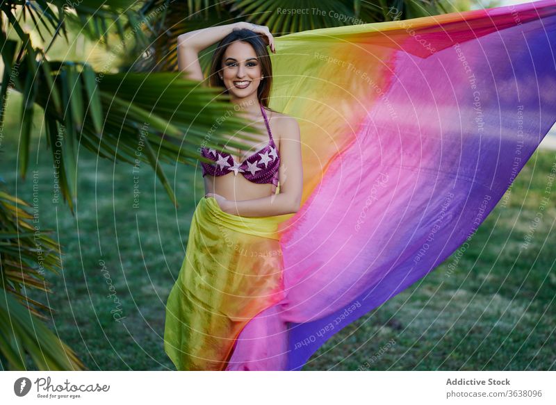 Smiling ethic female performing oriental dance woman dancer belly park sunset grace shawl ethnic tradition costume green creative energy move sundown sunlight