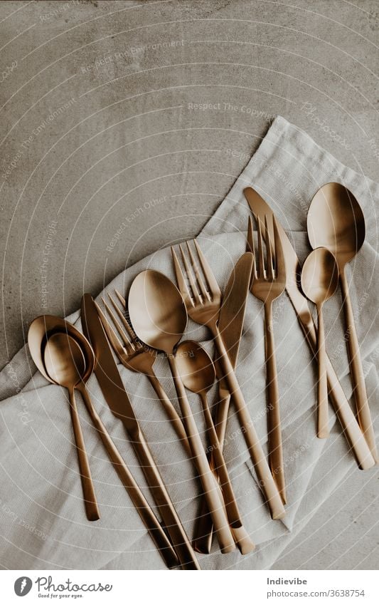 Golden cutlery composition on grey background - spoon, fork and knife gold silverware utensils kitchenware isolated cooking food tool white spoons table