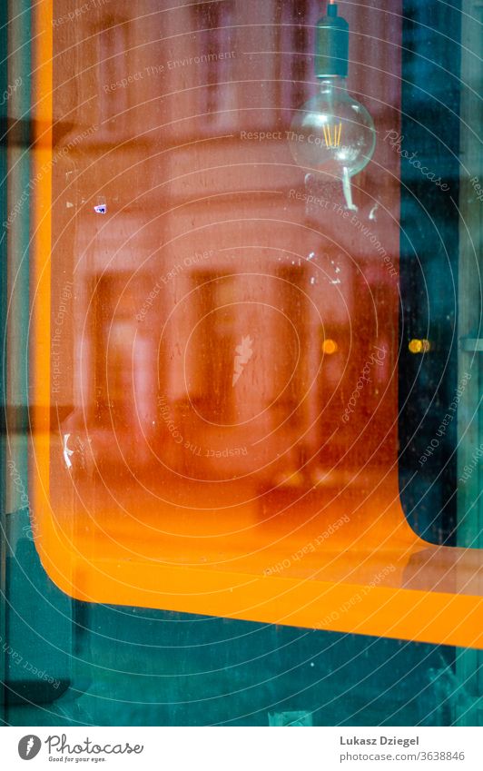 Shop window with a colorful element, a vintage bulb and a reflection of the building decorative color image outdoors abstract background old town old city