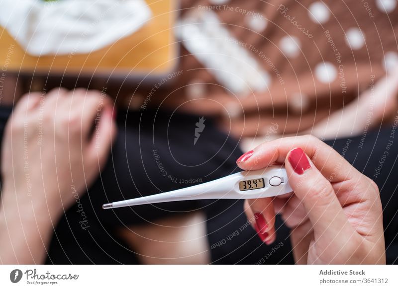 Crop woman with thermometer on bed temperature sick ill cold home disease suffer flu female sit flat unwell pain care domestic problem apartment measure lady