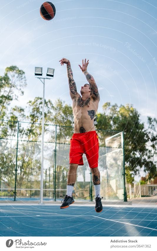 Male basketball player training on playground game man tattoo sportsman male energy healthy sporty muscular street urban sportswear concentrate exercise active