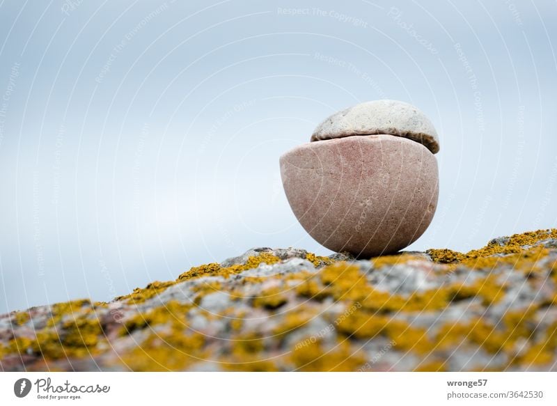printed matter | hemisphere experiment a la Otto v. Guericke - 2 halves of stone lying on top of each other on a large boulder on the beach of the Baltic Sea