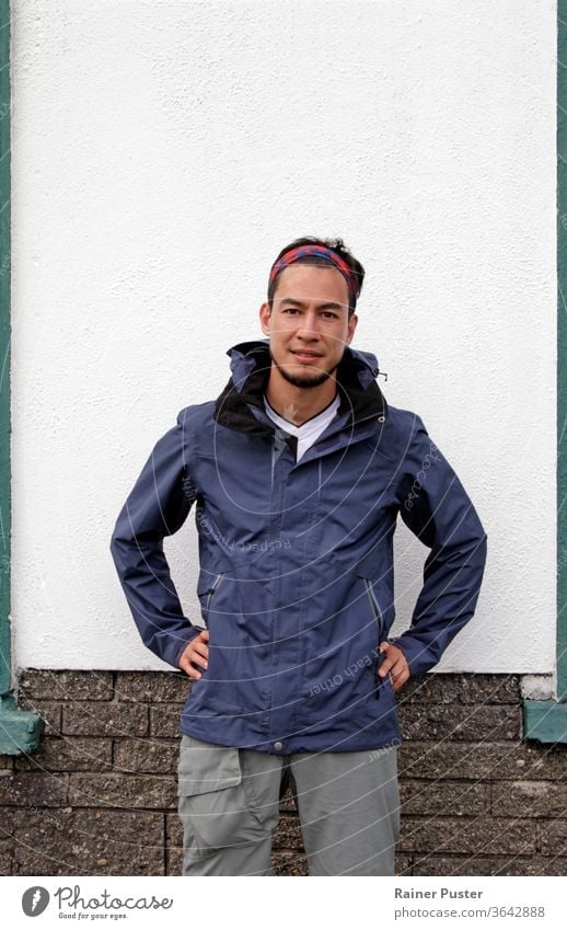 Young man in hiking outfit in front of white wall adult attractive bandana casual caucasian copy space face fashion guy handsome jacket lifestyle male model