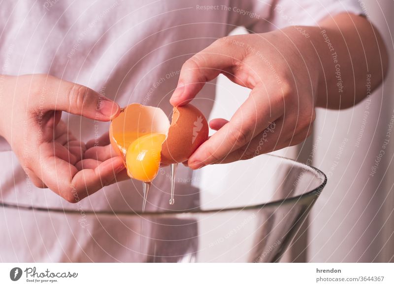 unrecognizable person cracking an egg in a bowl fractured food shell bake break baking cooking hand cookery utensil wooden breaking dough pastry cracked