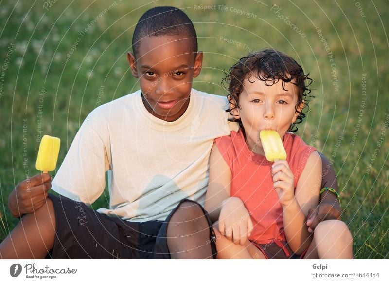 A couple of friends african appetite background black boy caucasian child children clear cold concept conceptual cream delicious dessert eat eating enjoy ethnic