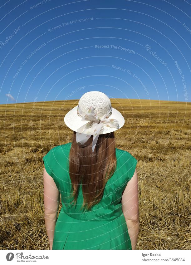 Rear View Of Woman Standing On Land Field Rear view Summer Clear sky Green Dress Hat Meadow Landscape Beautiful weather Freedom Lifestyle Copy Space