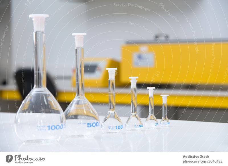 Collection of glass flasks on table laboratory equipment row various modern experiment science tool workplace research technology chemistry scientific prepare