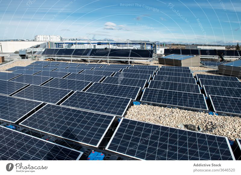 Solar panels on roof of building solar battery alternative renewal energy resource ecology sustainable contemporary construction daytime sun sunny rooftop