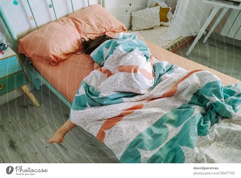 Girl sleeping covered up in her bed unrecognizable lazy girl sleepy morning deeply asleep bedroom young pillow tired female home caucasian indoor