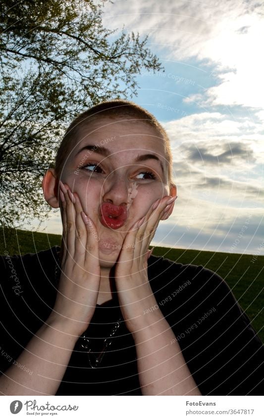 Young woman with very short hair, hands on her cheeks, makes funny face - a  Royalty Free Stock Photo from Photocase