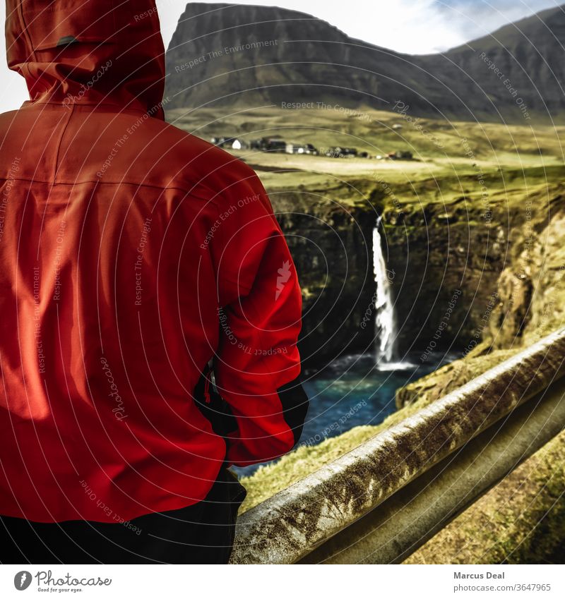 Solo traveller looking towards waterfall in the Faroe Islands Faroe islands faroese solo solo traveller one person red jacket rural mountain nature pretty