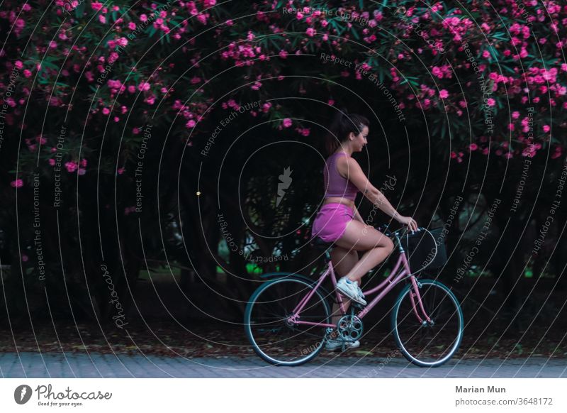 chica montando en bici rosa en el campo flores naturaleza belleza movimiento deportes airelibre divertido biciletas