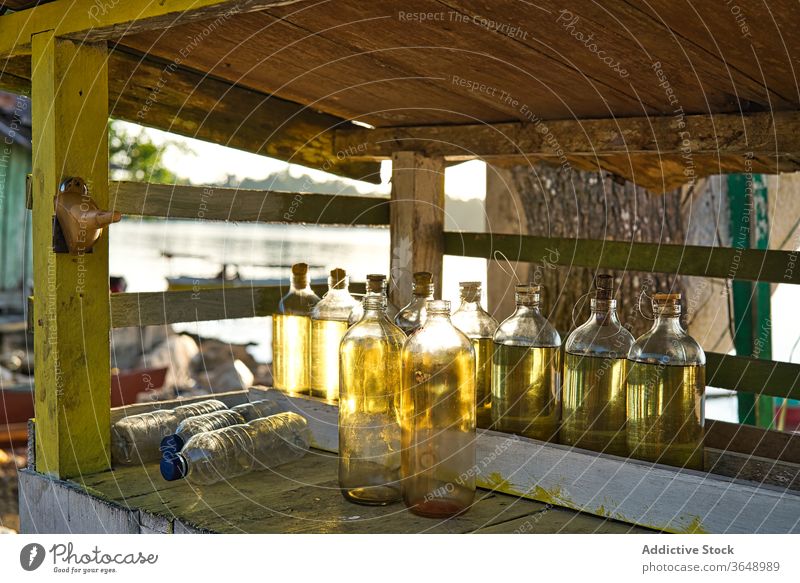 Bottles with oil on shelf in countryside bottle rural nutrition wooden shabby glass rustic organic sunny area natural timber daytime lumber tradition fresh