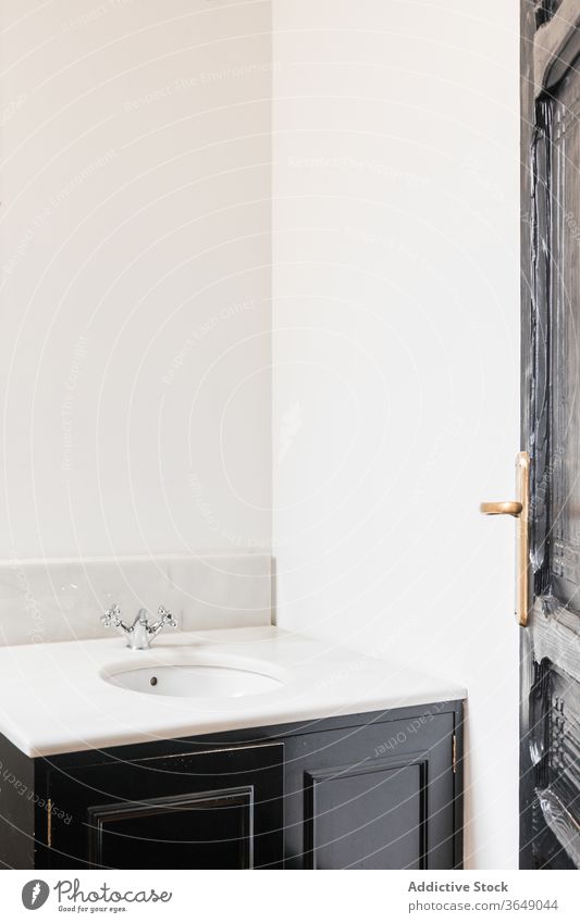 Modern minimalist style bathroom interior at home sink vanity unit tap modern hardwood stainless steel wooden metal material open door smooth surface golden