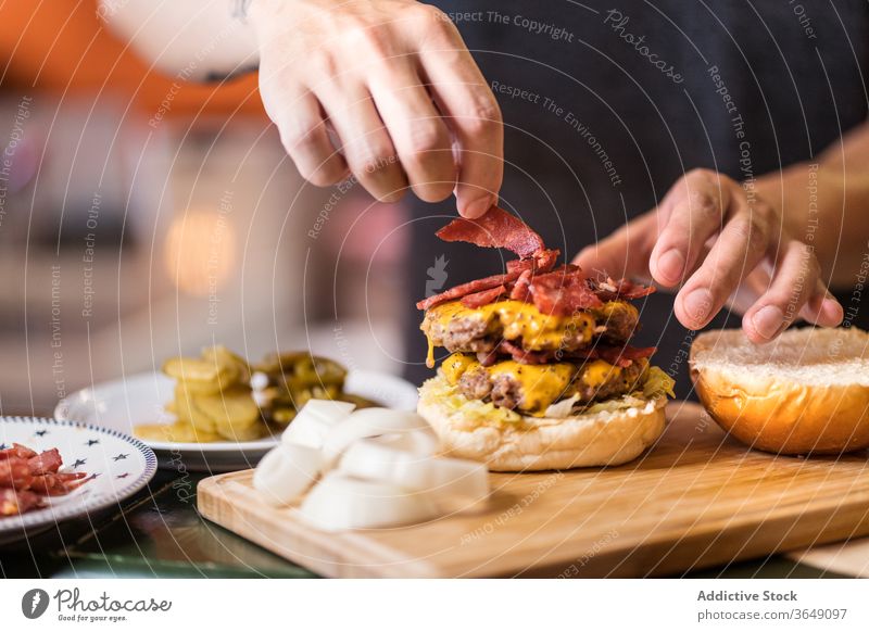 Asian male cook preparing burger in cafe tasty prepare man meat cutlet add food asian ethnic delicious meal table chef cuisine gourmet dish professional beef