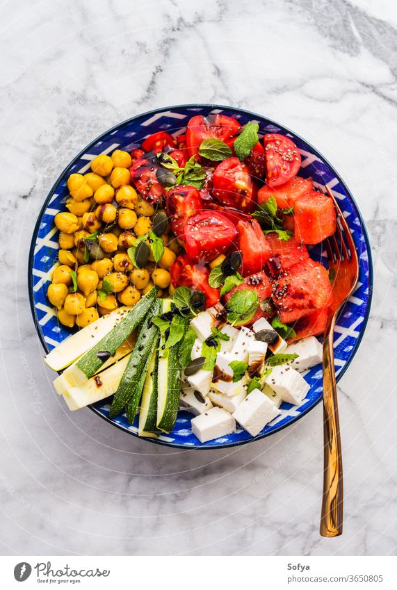 Chickpea watermelon salad with feta and tomatoes food colorful turmeric chickpea cheese top view flat lay zucchini mint balsamic vinegar marble table summer