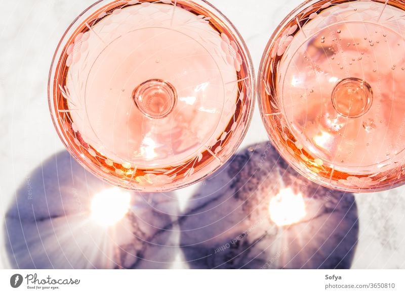 Two crystal stemmed glasses with rose wine white marble party pink drink dinner table luxury light background modern alcohol bar beautiful celebration concept