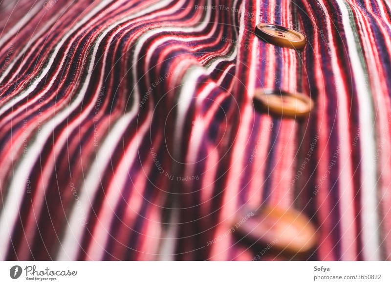 Detail of button down striped dress detail selective focus texture female fabric textile woven cotton thread color colorful red pink dark angle view fashion