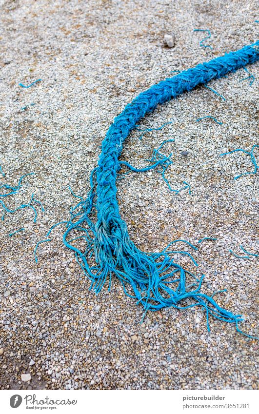 Torn blue rope Rope Dew Blue Street Asphalt Broken Lie load limit Fringe Maritime Exterior shot Harbour Colour photo Deserted fails Day Close-up