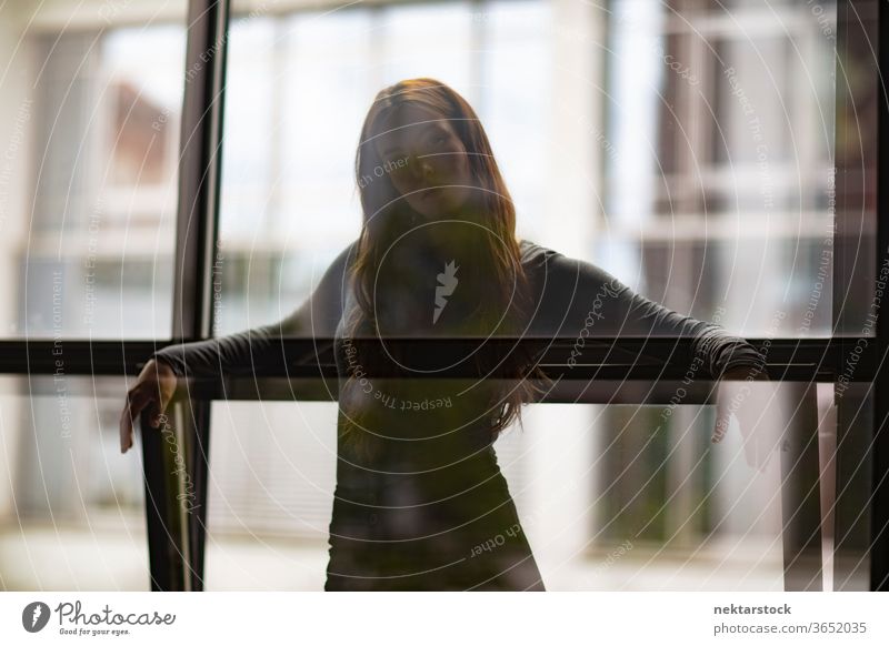 Attractive Woman Behind Window Glass Partition female one person girl young woman glass silhouette three quarter length window contemplation thought