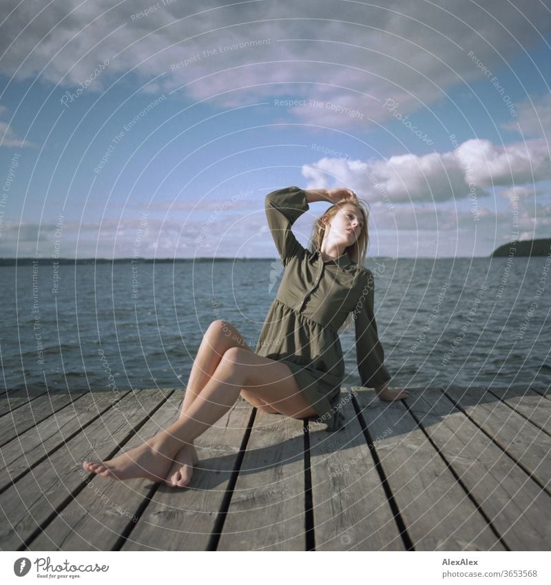 analogue full body portrait of a young, blond, barefoot woman on a wooden jetty in the sea Woman Young woman Blonde already Slim Long-haired windy Esthetic